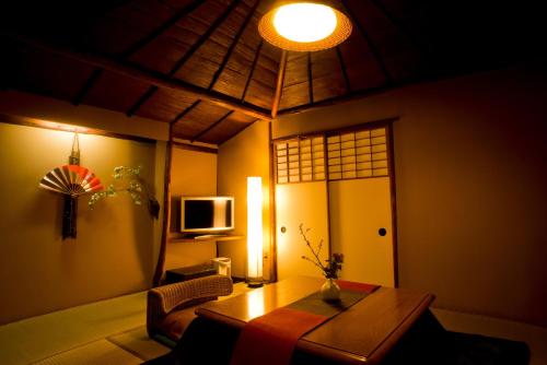 a living room with a table and a tv at Yamagaso in Hakone