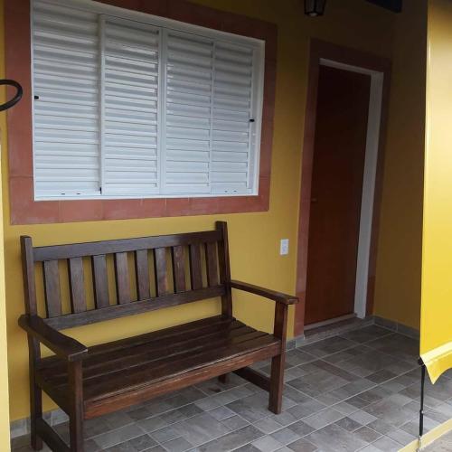 a wooden bench sitting in a room with a window at Pousada Sítio Pedras de Minas in Monte Sião