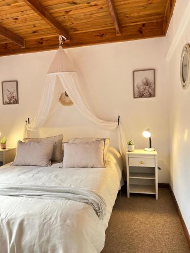 1 dormitorio con cama blanca y mesa en Casa Toscana junto al río, en El Bolsico