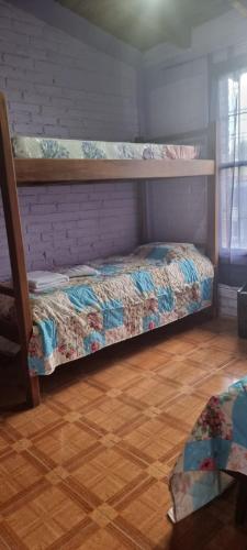 1 dormitorio con 2 literas y suelo de madera en Alquiler turístico en Maipú