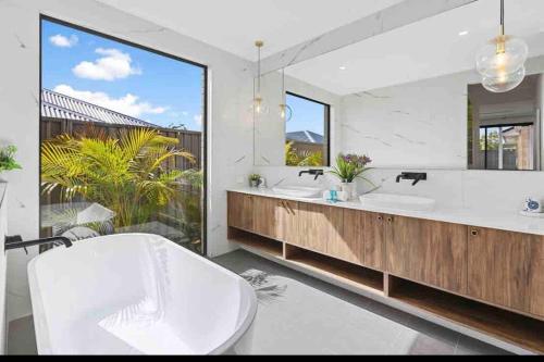 Un baño con dos lavabos y un espejo grande. en Skylight Splendour!, en Perth