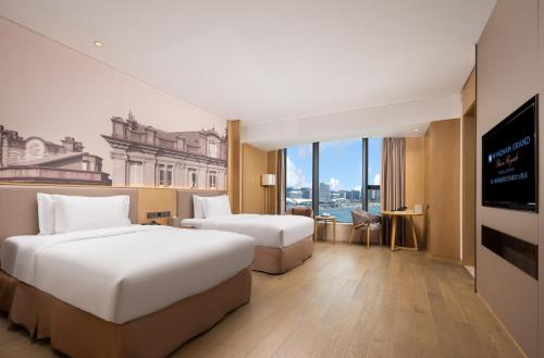 um quarto de hotel com duas camas e uma televisão de ecrã plano em Wyndham Grand Plaza Royale Yuzhou Xiamen - Wuyuan Bay em Xiamen