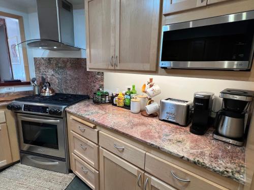 a kitchen counter with a stove and a microwave at Villa La Reforma - Newly Designed 4BR HOUSE & POOL in Los Angeles by Topanga in Los Angeles