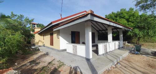 una pequeña casa con techo rojo en La Felicita en Mannar
