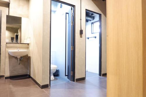 La salle de bains est pourvue de toilettes et d'un lavabo. dans l'établissement bangkok bed place, à Bangkok