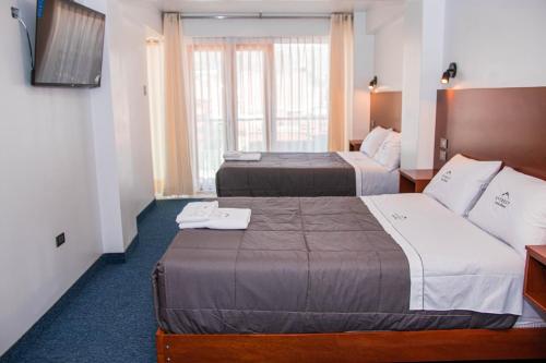 a hotel room with two beds and a television at Hotel Turístico Everest in Huaraz