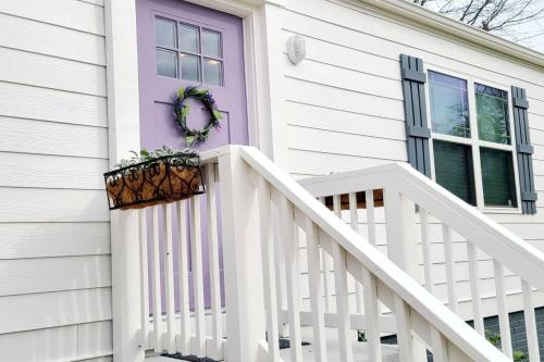 une maison blanche avec une porte violette et des escaliers dans l'établissement 10 Mins Downtown 20 Mins Airport PET FRIENDLY, à Decatur