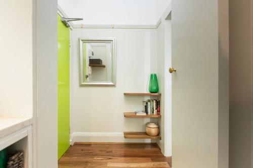 un pasillo con paredes verdes y blancas y un espejo en Tranquil 1 Bedroom Apartment - Rushcutters Bay Self-Catering en Sídney
