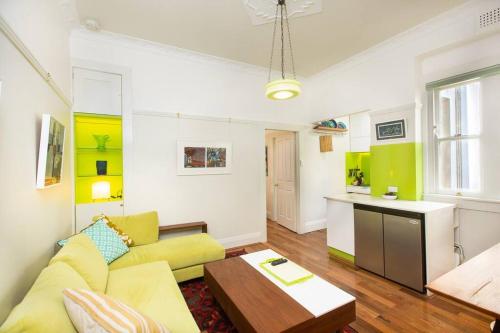 sala de estar con sofá amarillo y mesa en Tranquil 1 Bedroom Apartment - Rushcutters Bay Self-Catering, en Sídney