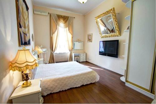 a bedroom with a white bed and a television at Ekaterina Apartments - Odessa in Odesa