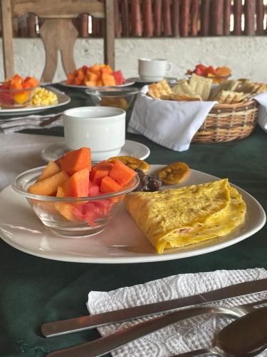 a plate with an omelet and fruit on a table at Ecohabitat in Xpujil