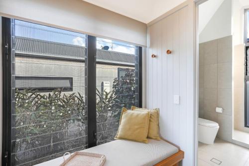 Cette chambre dispose d'une fenêtre et d'un banc avec un oreiller. dans l'établissement Reflections Bonny Hills - Holiday Park, à Lake Cathie