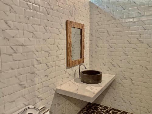 La salle de bains est pourvue d'un lavabo et d'un miroir. dans l'établissement Blue Sky Villa Ceningan, à Nusa Lembongan