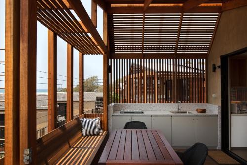 a kitchen with a wooden table and some windows at Reflections Bonny Hills - Holiday Park in Lake Cathie