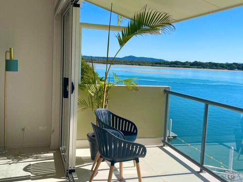 two chairs on a balcony with a view of the water at Noosa Shores apt 29-Noosa Heads-near Hastings St in Noosa Heads