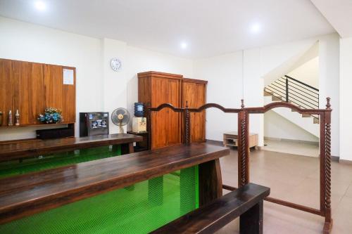 een kamer met een houten tafel en een trap bij Urbanview Syariah Kadarman Home Laweyan by RedDoorz in Grogol