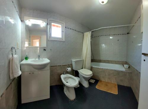 a bathroom with a toilet and a sink and a tub at ESPAÑA CENTRICO in El Bolsón