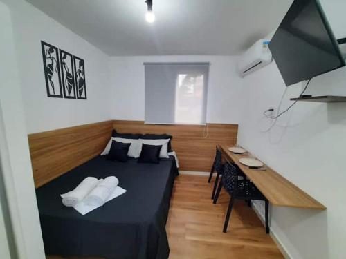 1 dormitorio con 1 cama con 2 almohadas y escritorio en Studio Próximo Av Paulista, en São Paulo