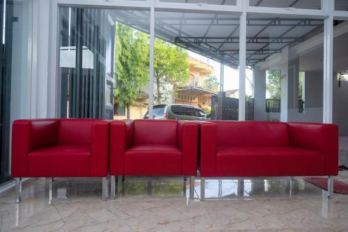 a row of red chairs sitting in a room at RedDoorz Syariah near Transmart Pabelan Solo in Kartosuro