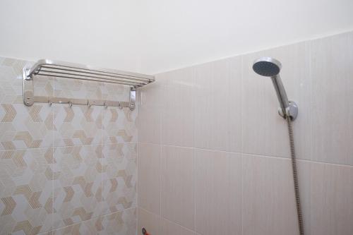 a shower with a shower head in a bathroom at RedDoorz Syariah near Transmart Pabelan Solo in Kartosuro