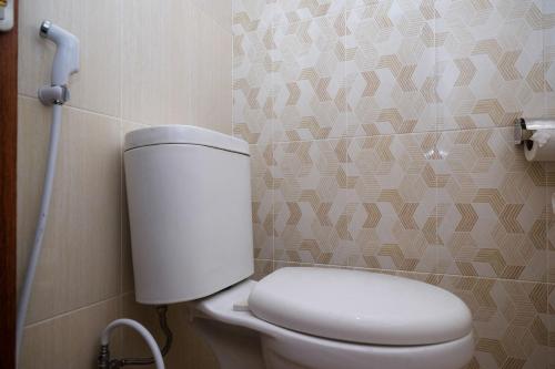 a bathroom with a white toilet in a room at RedDoorz Syariah near Transmart Pabelan Solo in Kartosuro