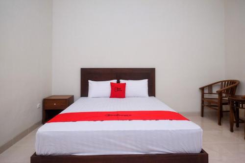 a bedroom with a bed with a red pillow on it at RedDoorz Syariah near Transmart Pabelan Solo in Kartosuro