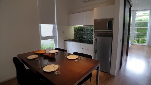 a kitchen with a wooden table with plates on it at Ecoloft Jababeka Golf in Cikarang