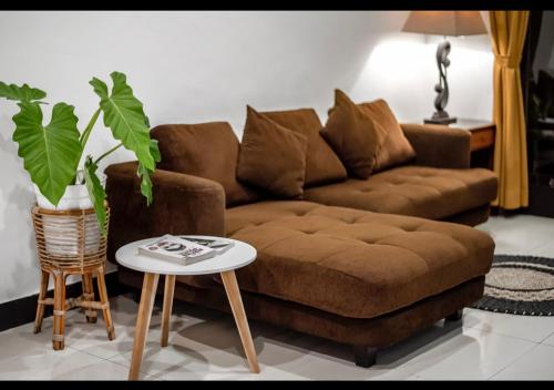 a living room with a brown couch and a table at Pondok Arya Kuta Villas by Kamara in Kuta