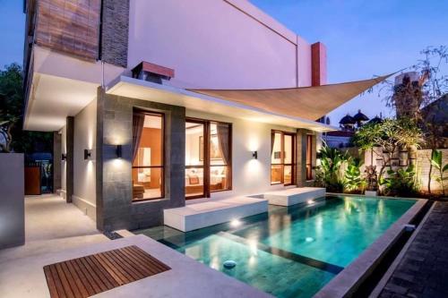 a swimming pool in the backyard of a house at Pondok Arya Kuta Villas by Kamara in Kuta