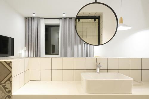 La salle de bains est pourvue d'un lavabo et d'un miroir. dans l'établissement Travel of Swan International Hostel, à Zhangjiajie