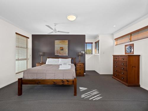 een slaapkamer met een bed, een dressoir en ramen bij Nautica on Marine Parade by Kingscliff Accommodation in Kingscliff