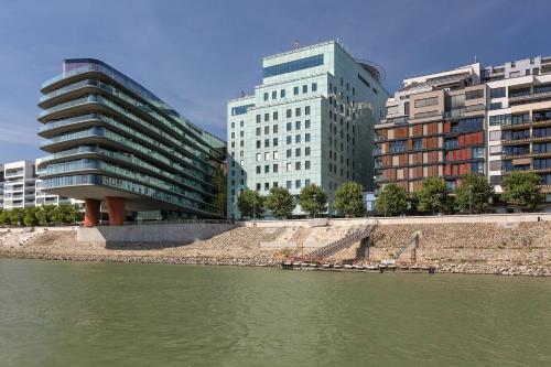 a group of buildings next to a river with buildings at Grand Hotel River Park, a Luxury Collection Hotel, Bratislava in Bratislava