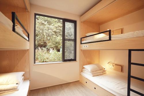 Cette petite maison dispose d'une fenêtre et de 2 lits superposés. dans l'établissement Travel of Swan International Hostel, à Zhangjiajie