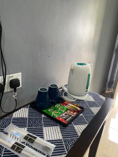 a table with a toaster and cups on it at Mutiara Chalet Bandar Melaka in Melaka