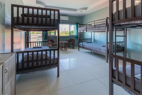 a room with four bunk beds and a table at HOUSE OF HAPPINESS in Thong Sala