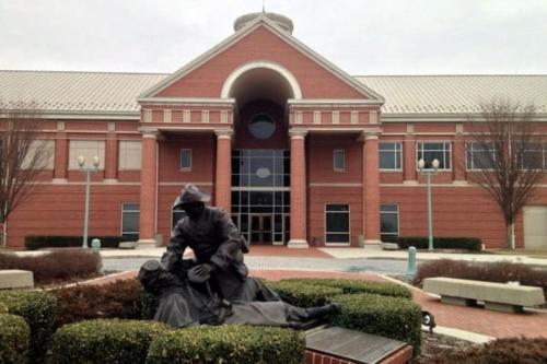 a person sitting on a statue in front of a building at Holiday Inn Express Harrisburg I-81 - Hershey By IHG in Manadahill