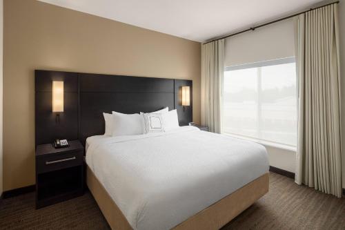 a large bed in a hotel room with a large window at Residence Inn by Marriott Portland Vancouver in Vancouver