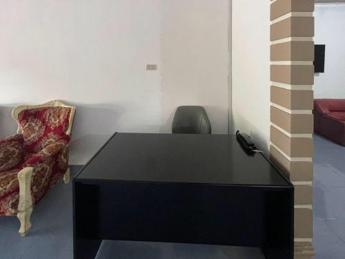 RedDoorz @ Balige Toba Samosir في باليج: مكتب أسود وكرسي في الغرفة