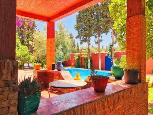 eine Terrasse mit einem Tisch und einem Pool in der Unterkunft Villa mogador in Essaouira