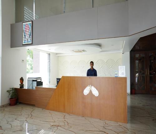 a man standing behind a counter in a lobby at Bamboo Saa Mulberry Resort Pushkar in Pushkar