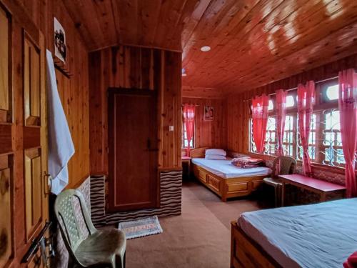 um quarto com 2 camas num quarto de madeira em Moktan Lakpa's Homestay em Bijanbāri Bāzār