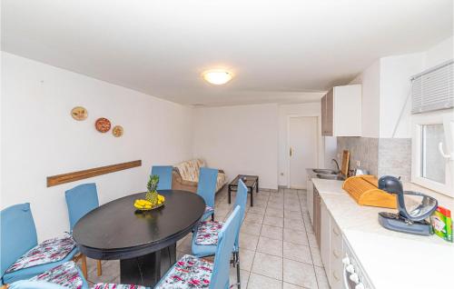 a kitchen and dining room with a table and chairs at Beautiful Home In Prgomet in Labin