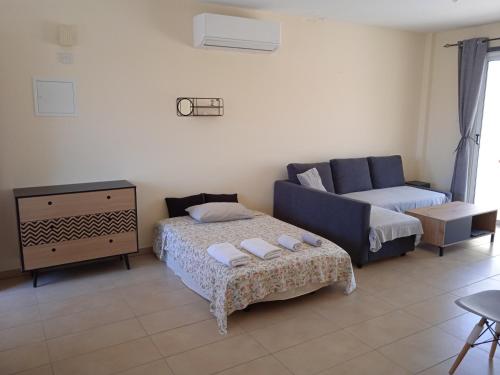 een woonkamer met een bank en een bed bij Xylophagou Rest and relax (2) Ayia Napa Larnaca in Xylophaghou