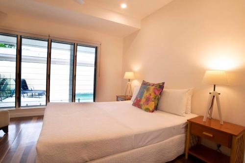 a bedroom with a bed and a large window at Beachfront on Mission - Absolute Beachfront in Mission Beach