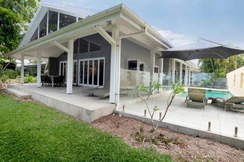 a house with a patio and an umbrella at Beachfront on Mission - Absolute Beachfront in Mission Beach