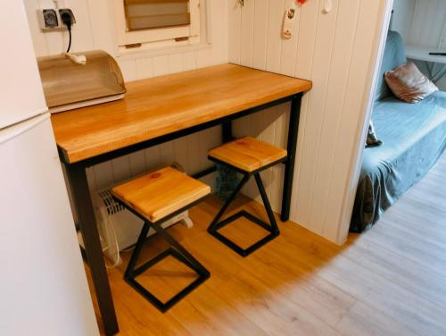 a small kitchen with a counter and two stools at Domek letniskowy przy Orliku Cisna działka in Cisna