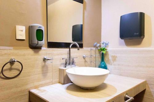 a bathroom with a bowl sink and a mirror at Suites Apodaca in Monterrey