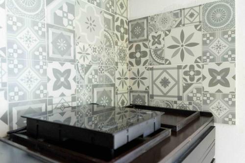 a bathroom with a tile wall with a glass counter at Suites Apodaca in Monterrey