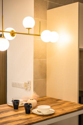 a kitchen with a counter with plates and lights at Twin Tower Residence by Nest Home【5 mins walk to CIQ】 in Johor Bahru