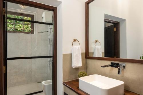 a bathroom with a white sink and a shower at The Grand Walawwa in Pinnawala